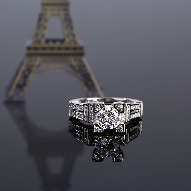 The Eiffel Tower - one of the world's most recognizable landmarks. Inspired by the Eiffel Tower, this ring perfectly demonstrates the structure and beauty of the tower. Crafted in sterling silver, this dazzling design showcases a round cut center stone wrapped in four smaller round stones. Along the shank, several stones complete the design of tower. The start of something beautiful, this glittering ring is sure to please.Carat Weight: 2.5 ctStone Size: 7 mmStone Type: Jeulia® StoneNumber of Stones: 1 Stone Color: Diamond WhiteStone Shape: RoundCarat Weight: 0.818 ctStone Size: 1,0.9,1.5 mmStone Type: Jeulia® StoneNumber of Stones: 74 Stone Color: Diamond WhiteStone Shape: RoundWeight: 5.43 gWidth: 9 mmHeight: 27.7 mmThickness: 3.2 mmMaterial: 925 SilverPlating Color: Silver Luxury Silver Diamond Ring Channel Set, Luxury Silver Channel Set Jewelry, Luxury Sterling Silver Channel Set Diamond Ring, Luxury Sterling Silver Diamond Ring Channel Set, Luxury Silver Diamond Ring With Round Band, Luxury Channel Set Diamond Ring In Sterling Silver, Luxury Diamond Cut Crystal Ring, Luxury White Gold Sterling Silver Halo Ring, Luxury Crystal Ring With Diamond Cut