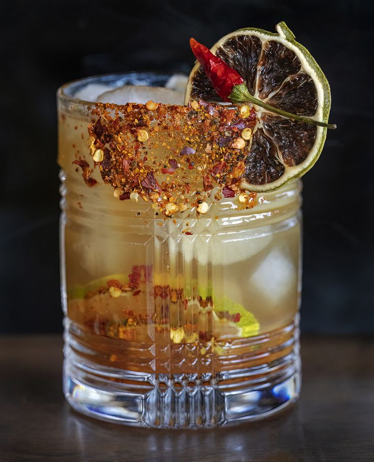 a glass with a drink and garnish on the rim