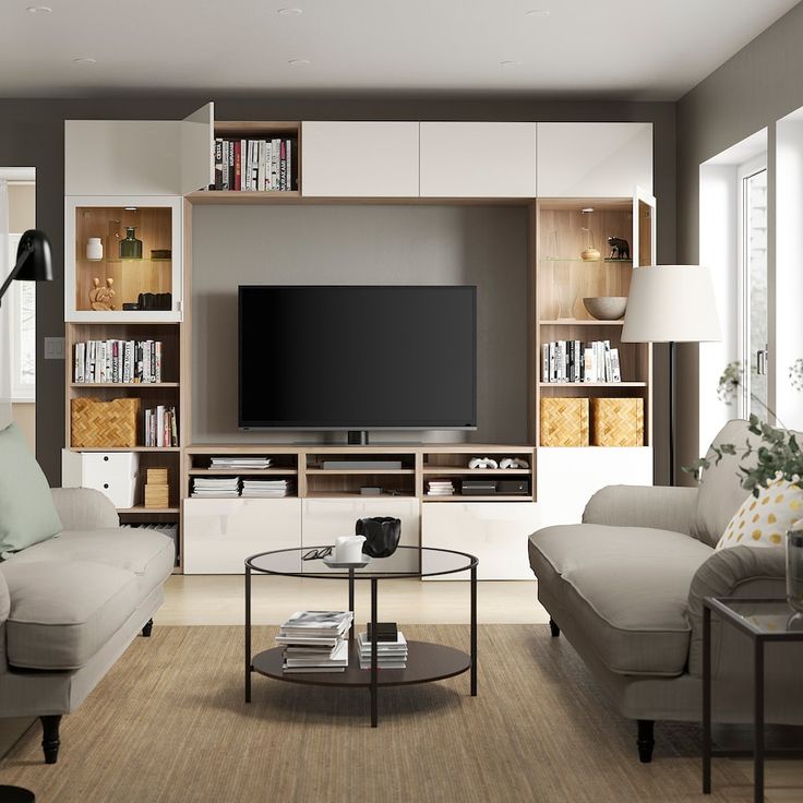 a living room filled with furniture and a flat screen tv mounted on a wall above a coffee table