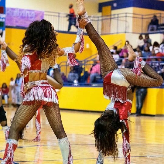 two cheerleaders perform on the court during a basketball game