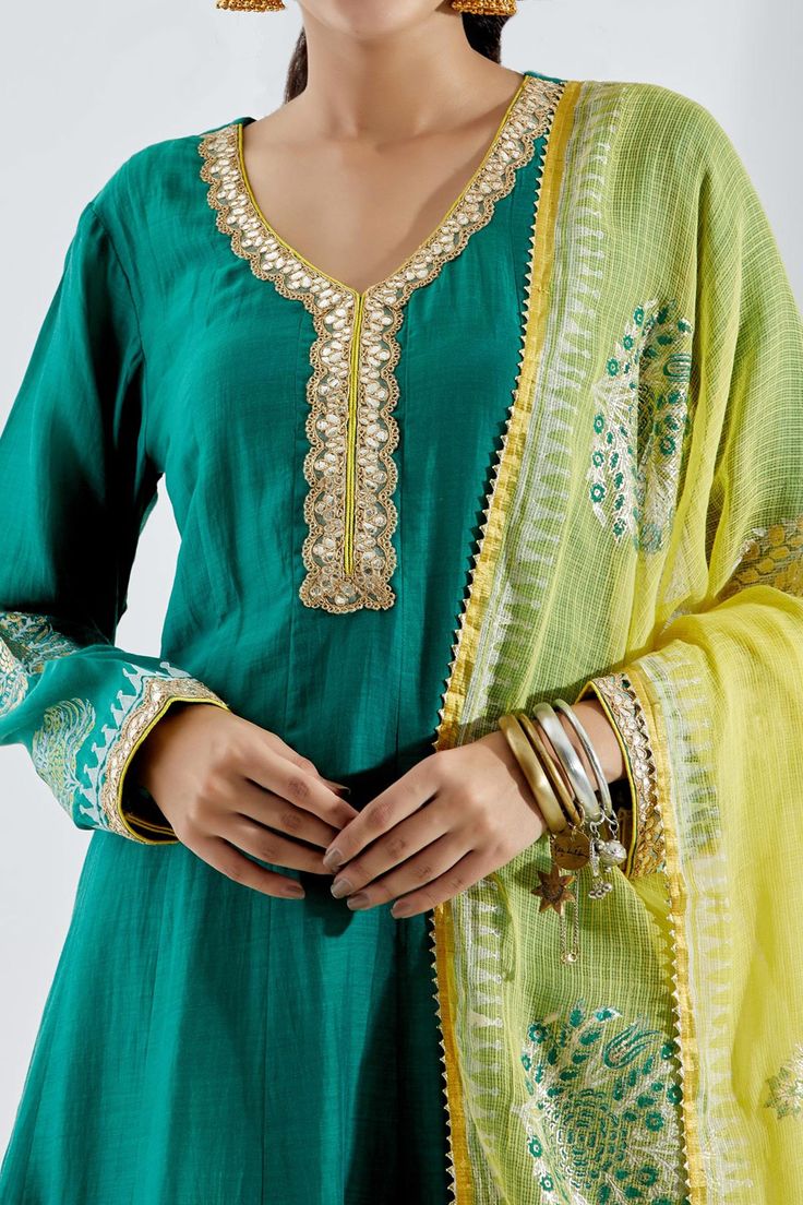 Emerald green anarkali set comes with gota pati neck and gota detailing. Paired with cotton silk block printed palazzo, co-ordinated with gota kingri lace. Comes with contrast foil printed kotta dupatta with gota kingri lace finish.
Component: 3
Print
Neckline: V-Neck
Sleeve Length: Full
Fabric: Cotton Silk
Color: Green
Cutwork dupatta and palazzo hem - Aza Fashions Emerald Green Anarkali, Green Anarkali, Printed Anarkali, Palazzo Set, Luxury Sale, Silk Embroidery, Cut Work, Foil Print, Green Cotton