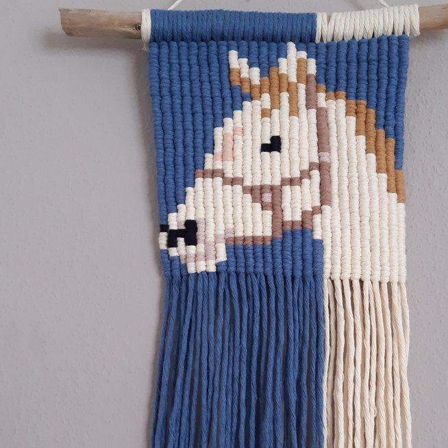 a blue and white wall hanging with a horse on it's side, next to a wooden stick