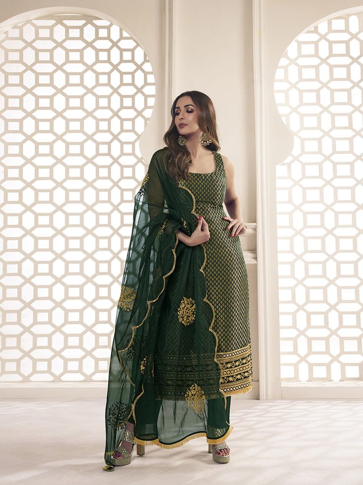 This great winter ensemble from Malaika Arora is perfect for your next special occasion. It includes a bottle green kurta set crafted from silk blend brocade, cotton and organza. Featuring Zari woven designs, a U-neck and calf length trousers, this set is sure to make a statement. It is dry clean only and designed specifically by the Bollywood Diva herself. TOP: Silk Blend(Brocade), TOP INNER: Cotton, BOTTOM: Cotton, DUPATTA: Organza, Dry Clean Semi-stitched Embroidered Green Kurta, Green Embroidered Georgette Sharara, Green Bollywood Churidar With Zari Work, Festive Bollywood Unstitched Suit In Pista Green, Bollywood Style Pista Green Unstitched Suit For Festive, Semi-stitched Embroidered Green Sharara, Designer Green Chanderi Salwar Kameez, Green Churidar With Dabka Work In Traditional Drape, Green Sets With Zari Work In Georgette