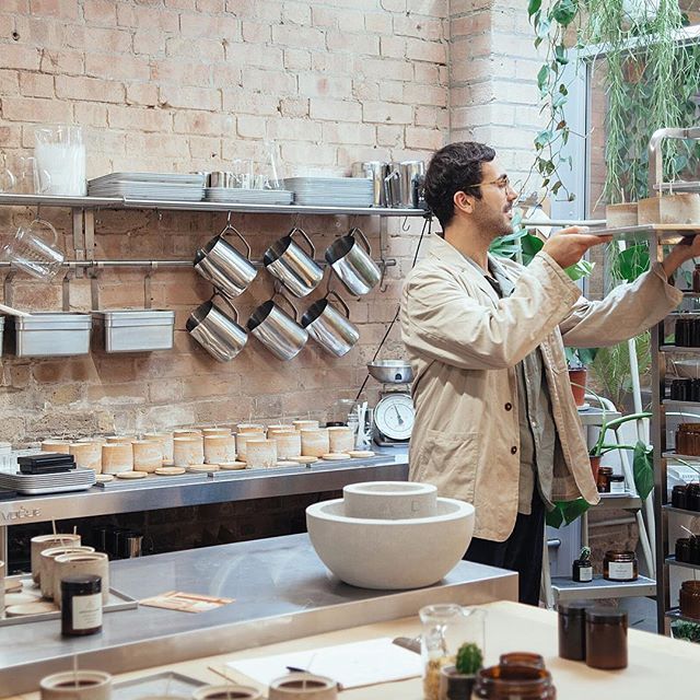 a man in a kitchen holding a tray with food on it