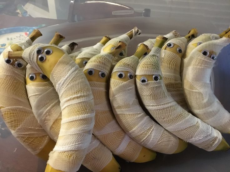 there are bananas wrapped in bandages and eyes on each banana's faces, as if they were made out of bandages