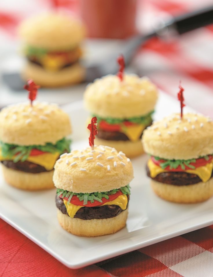 mini hamburgers with candles are on a plate