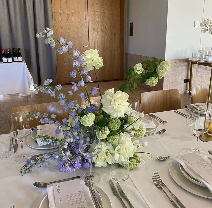 the table is set with flowers and silverware