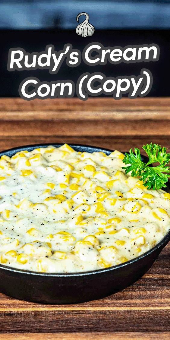 a bowl of creamy corn dip on a wooden table with a sign that says rudy's cream corn copy