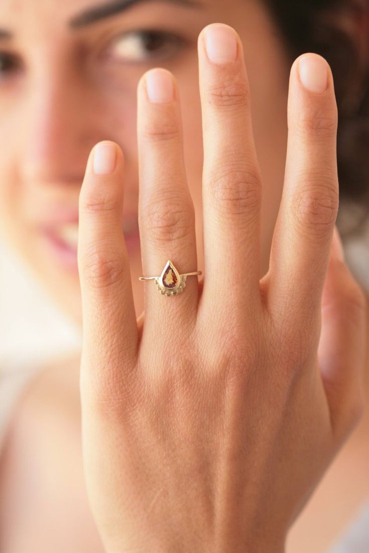 a close up of a person wearing a ring with a diamond on it's finger