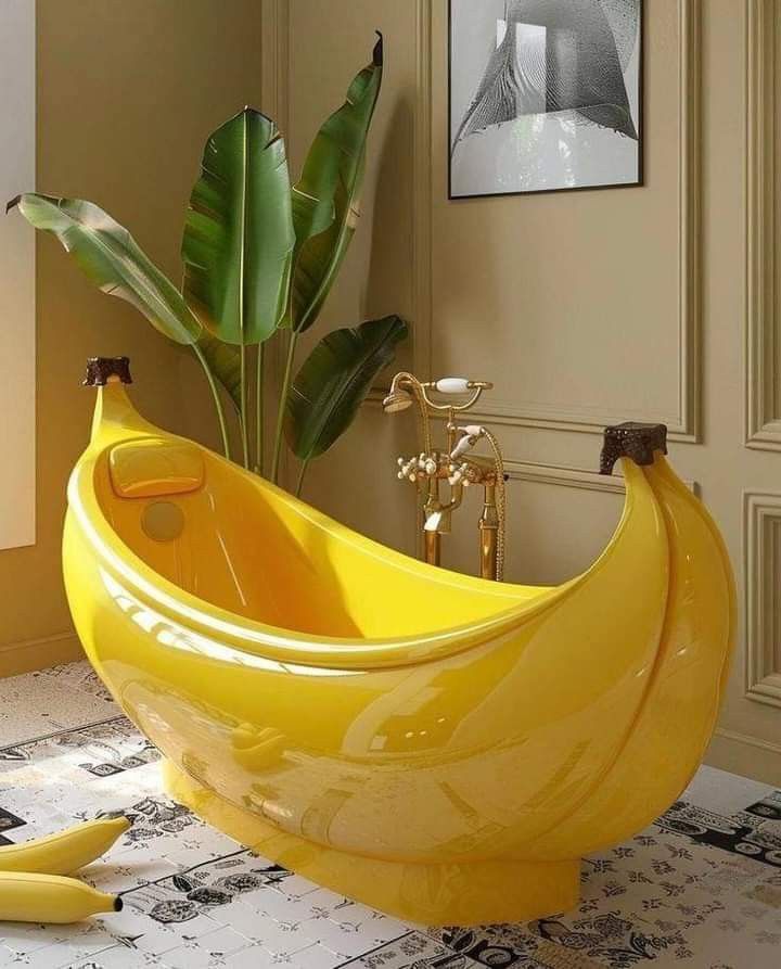 a large banana shaped bathtub sitting on top of a bathroom floor next to a plant