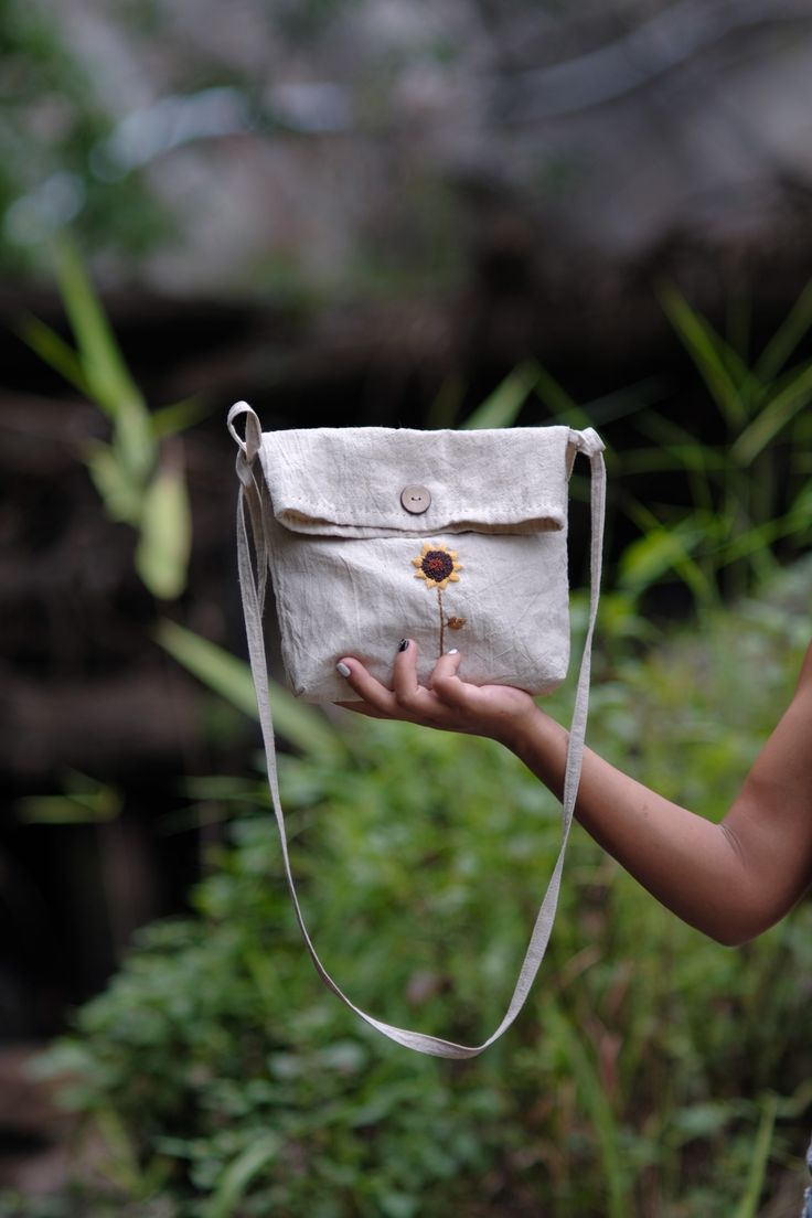 a woman holding a white bag with a flower on it