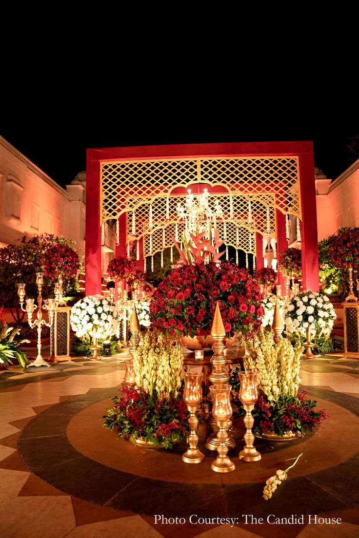 an elaborately decorated courtyard at night with flowers and candles