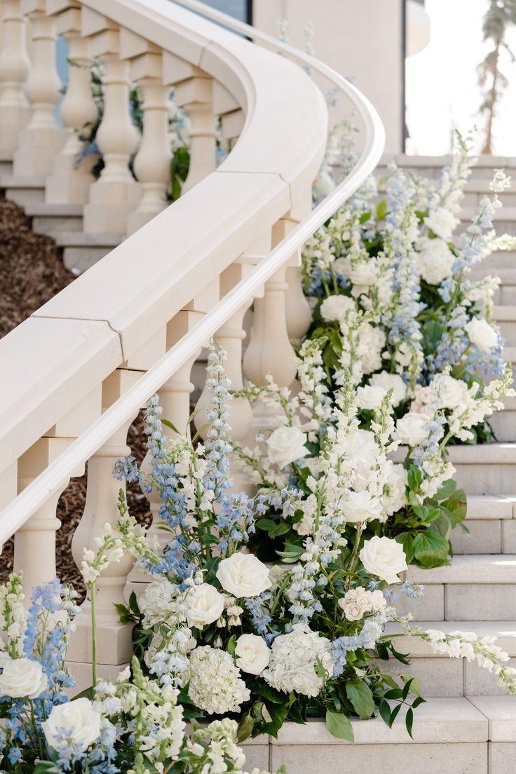 some white and blue flowers are on the stairs