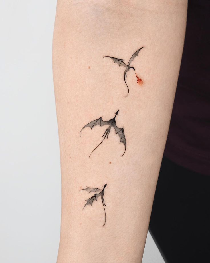 a woman's arm with three small birds on the left side of her body