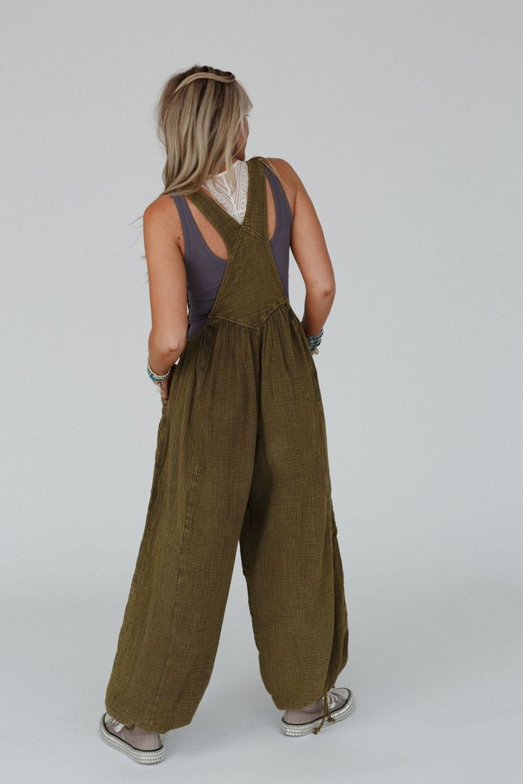 Get ready to look effortlessly boho - chic and ready - to - go in the Coastal Muse Wide Leg Jumpsuit! Feel authentically you in this cute jumpsuit because it features: Comfortable, lightweight, mineral - washed Cotton gauze fabric Loose and slouchy jumpsuit overall silhouette Classic square neckline with adjustable button straps Flattering gathered pointed center seams Oversized wide pant legs with unique tied gathered details along the ankles Convenient side pockets, a single cargo pocket along Slouchy Jumpsuit, Cute Jumpsuit, Cotton Gauze Fabric, Padded Bralette, Gauze Fabric, Cargo Pocket, Wide Pants, Neon Lights, Square Necklines