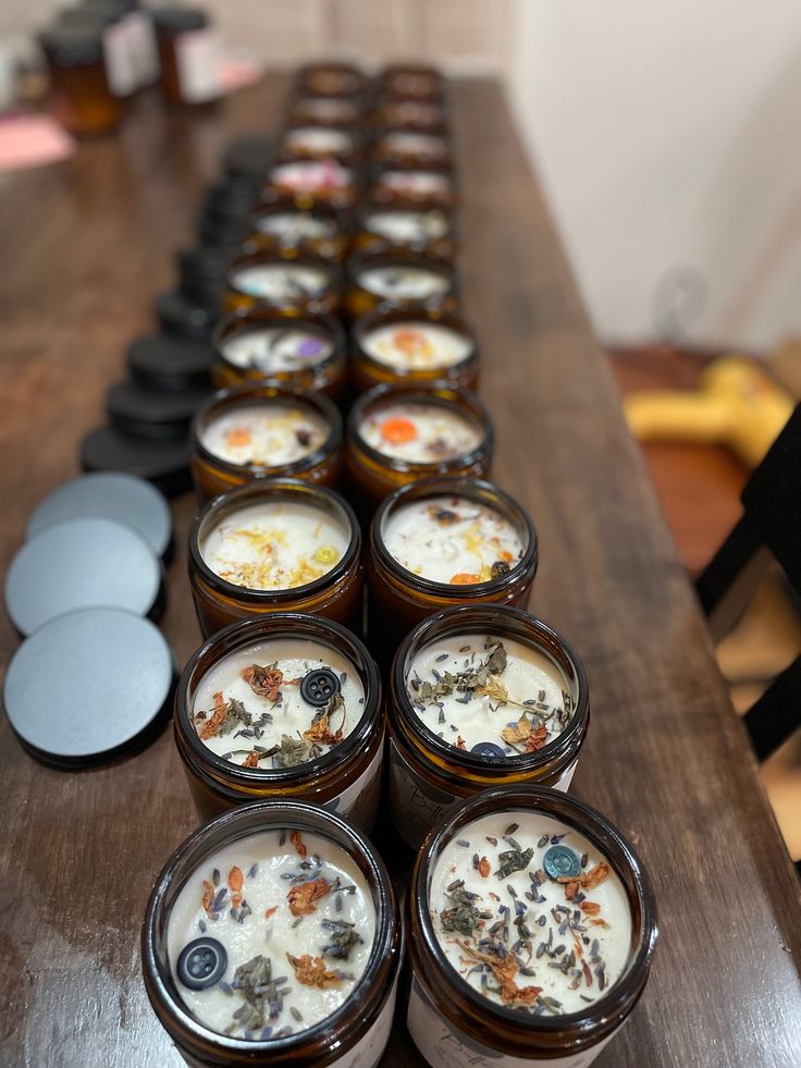 several jars filled with food sitting on top of a wooden table next to each other