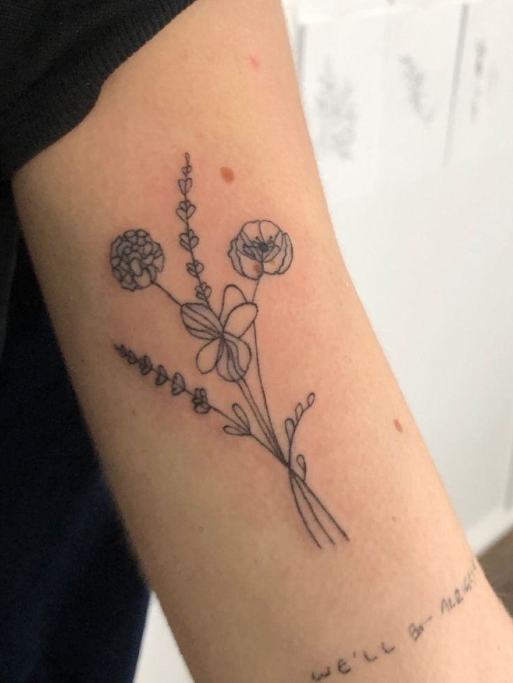 a woman's arm with a flower tattoo on the left side of her arm