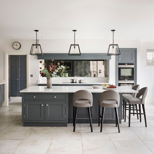 a large kitchen with gray cabinets and stools