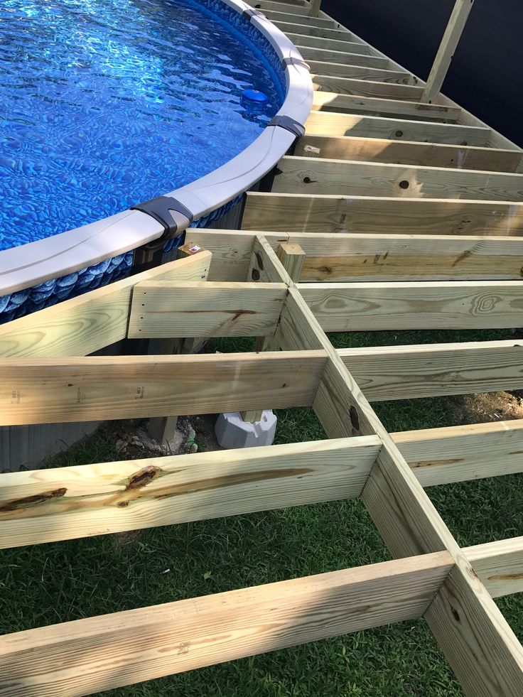 an above ground swimming pool with wooden steps leading up to the bottom and side wall