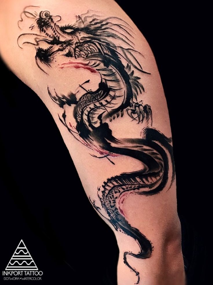 a dragon tattoo on the leg of a person's leg, with black ink