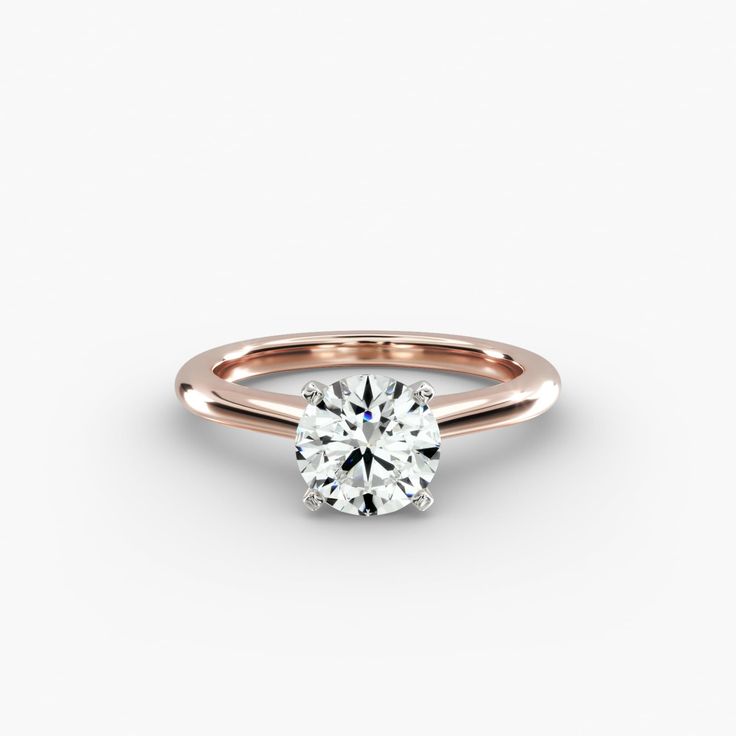 a rose gold engagement ring with a round brilliant cut diamond in the center, on a white background