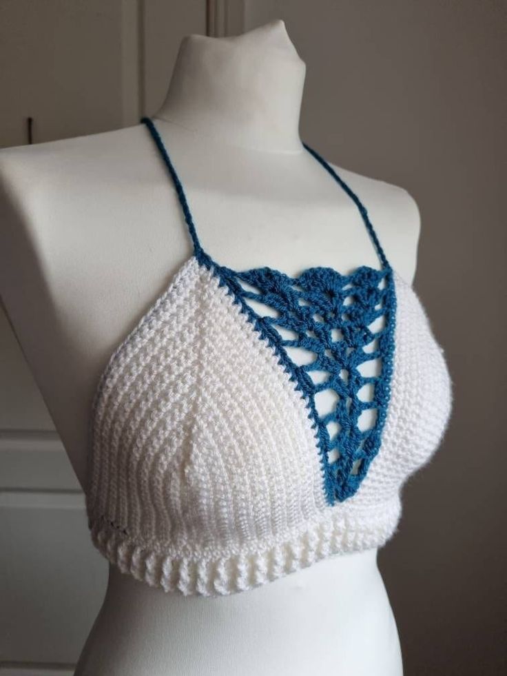 This one of a kind bralette will make you stand out wherever you go!  Featuring:  Deep V blue shell detailing! White ribbing around the waist! A criss cross back! Made in both white and turquoise 100% acrylic yarn.  Perfect for festivals with high waisted denim shorts or harem pants!  Bralette pictured is made to fit size medium and is ready to dispatch!  Please note, ALL OTHER SIZES WILL BE MADE TO ORDER AND DISPATCHED WITHIN 14 DAYS OF PURCHASE!  Full Sizing details:  Small - A-B cup  Medium - White Halter Neck Crop Top With Built-in Bra, White Crop Top With Built-in Bra, White Triangle Crop Top With Built-in Bra, White Halter Crop Top With Built-in Bra, White Triangle Top Bra Friendly, White Triangle Top With Bra-friendly Design, White Triangle Top With Bra Friendly Design, Festival Bra Friendly Cropped Top, Handmade White Halter Top For Vacation