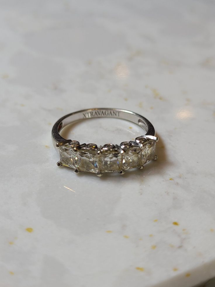 a three stone ring sitting on top of a counter