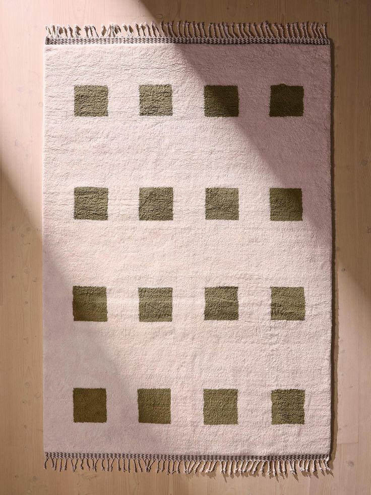 a white rug with green squares on it