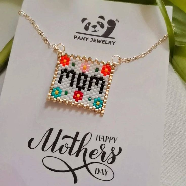 a mother's day card with a cross stitch necklace on it and a panda bear