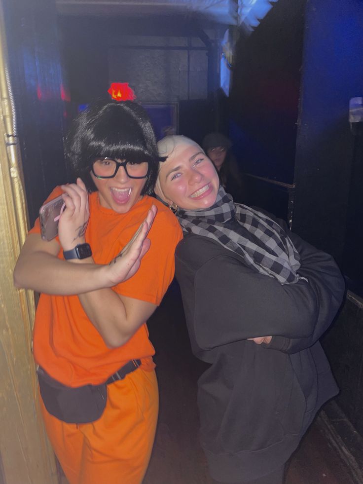 two women in orange are hugging each other