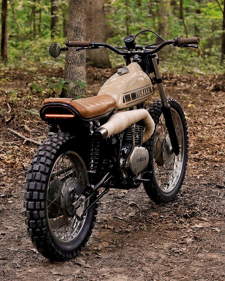 a dirt bike parked in the middle of a forest with no one around on it