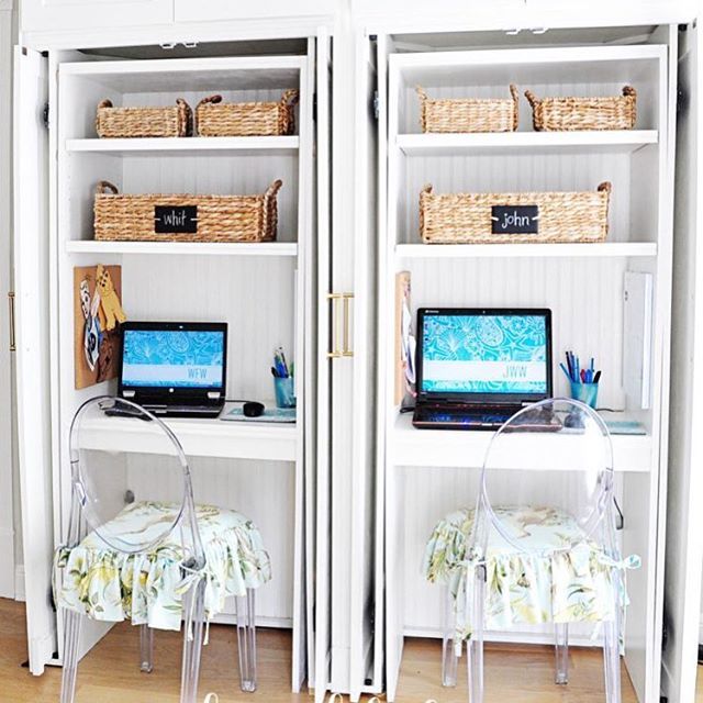 two computer screens sitting on top of a white bookcase