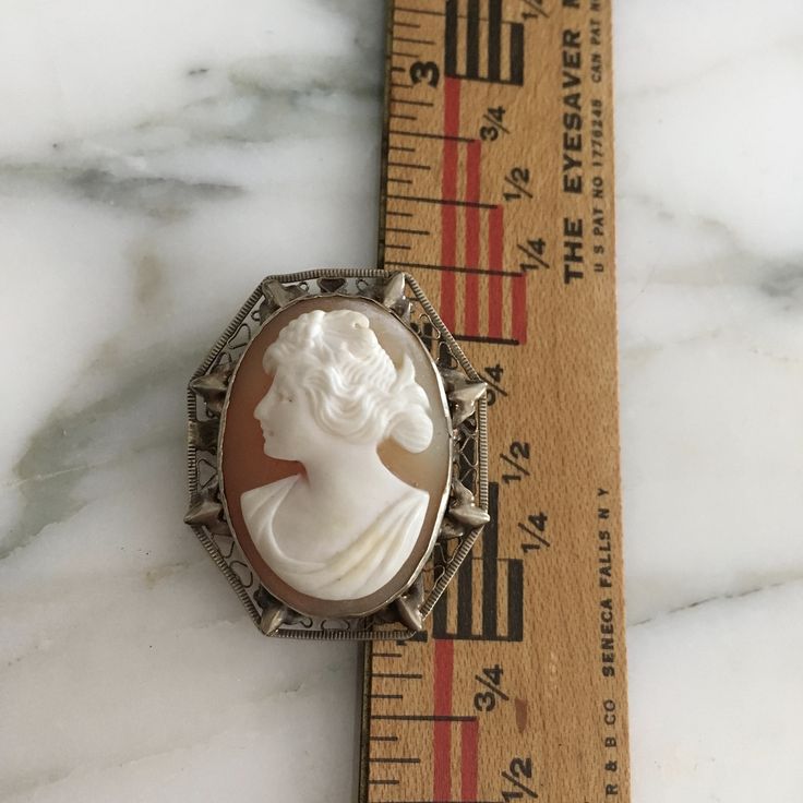 "14K white gold Small cameo. Very ornate, filigree setting holds a wonderful carved cameo of a beautiful Victorian women from the Edwardian era. This cameo can be both a brooch or a pendant. Brooch was made in the early 1900's and measures over 1 3/16\" in length X approximately 1\" in width. What makes this cameo so special is the fine detailed carving and wonderful delicate intricate frame, a tiny treasure. Shipping includes insurance. As always, local pickup is available. Aphrodite's Antique White Cameo Brooch For Formal Occasions, White Cameo Brooches For Formal Occasion, White Ornate Brooch For Formal Occasions, Ornate White Brooches For Formal Occasions, White Ornate Brooches For Formal Occasions, Heirloom White Brooch For Formal Occasions, Heirloom Style White Brooch For Formal Occasions, Heirloom White Brooches For Formal Occasions, Victorian White Cabochon Brooches