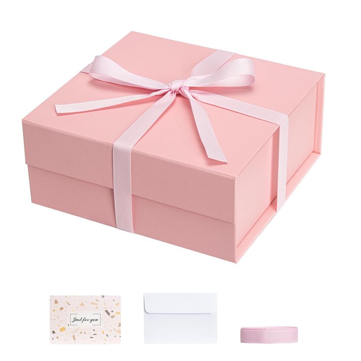 a pink gift box with a white ribbon and matching envelopes, along with other items