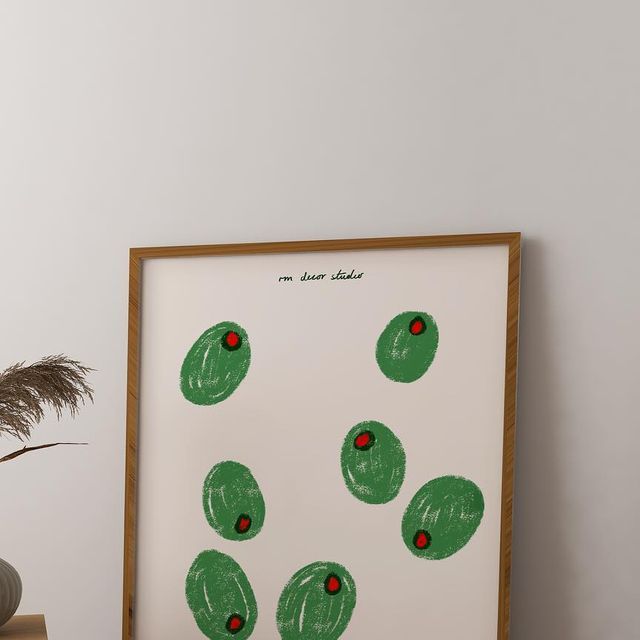 an art print with green circles and red dots on white paper in a wooden frame