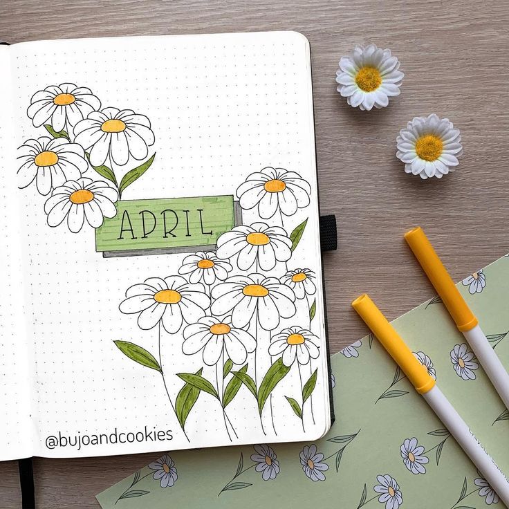 an open notebook with daisies and flowers on it