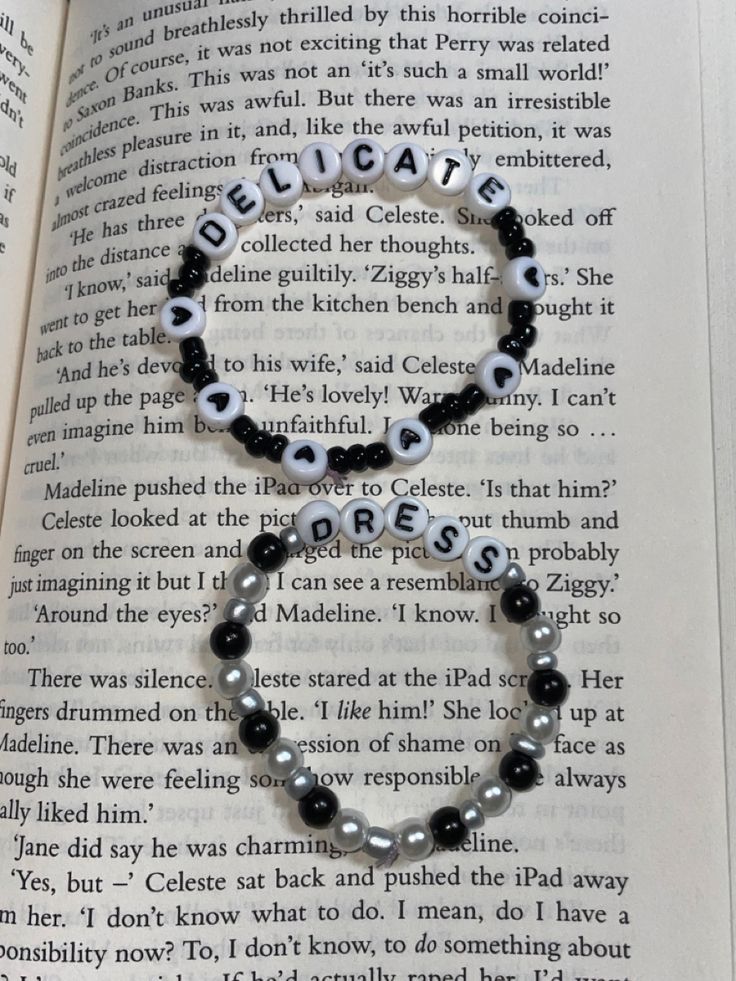 an open book with a black and white beaded bracelet on it