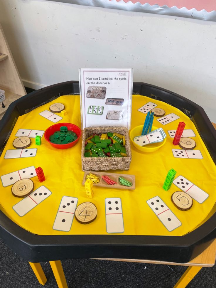 a yellow table topped with lots of different types of toys and games on top of it