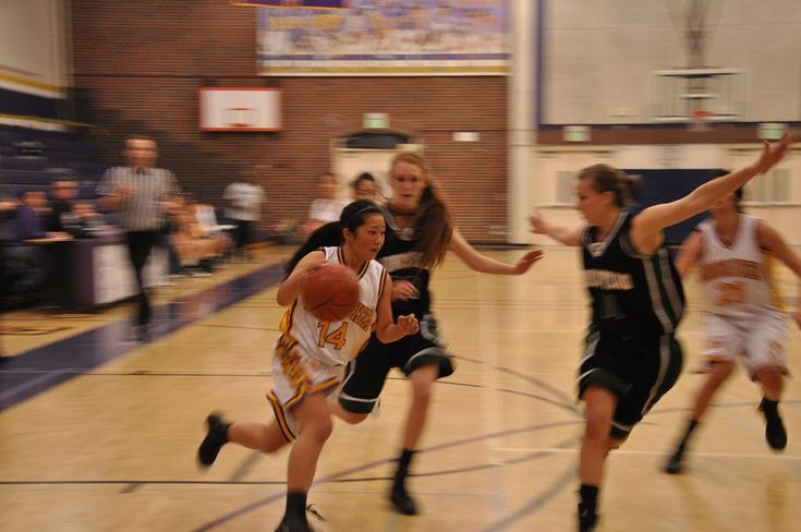 some girls are playing basketball on a court