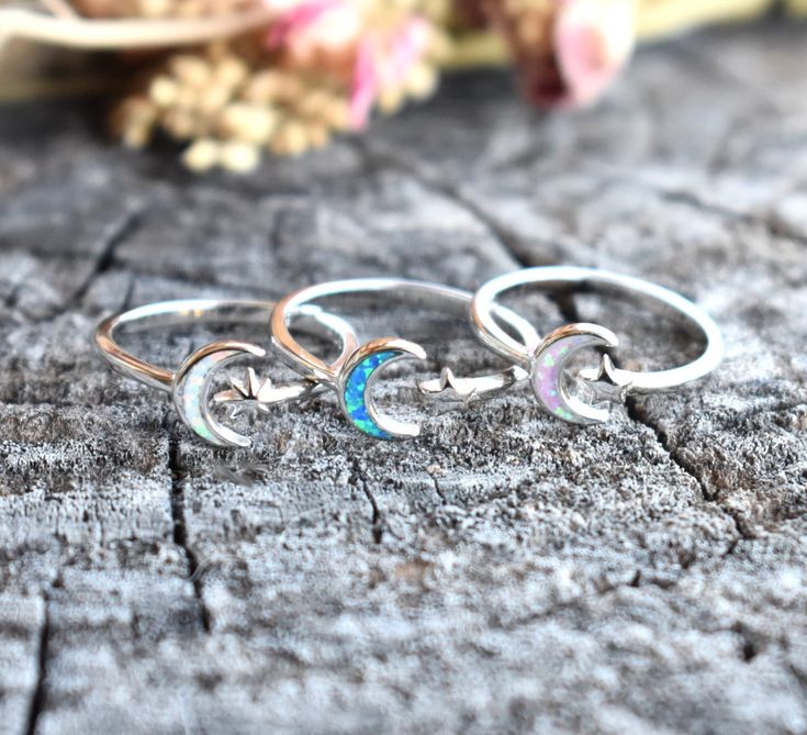 "Opal Moon & Star Ring: -Solid .925 sterling silver -Face height 8mm on 2mm width ring band -Color choice Pink or blue opal with 5 point star, or white opal with North star. -Comfortable and easily stackable! -Available in US sizes 3-13 with half sizes.  More rings here: https://www.etsy.com/shop/AWildViolet?ref=seller-platform-mcnav&section_id=13958646 Looking for a last minute or unique Christmas gift? Visit our \"READY TO SHIP\" section here, ships out in one business day https://www.etsy.com Celestial Crescent Moonstone Ring, Celestial Style White Gold Rings, Adjustable Celestial Star-shaped Rings, Celestial Sterling Silver Moonstone Open Ring, Mystical Silver Rings With Moon Phase, Sterling Silver Crescent Moonstone Promise Ring, Silver Crescent Moonstone Ring In Celestial Style, Silver Celestial Moonstone Ring, Celestial Silver Moonstone Ring With Sun And Moon Design