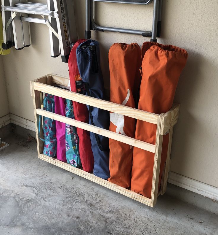 the umbrellas are lined up against the wall and hanging on the rack in front of the door