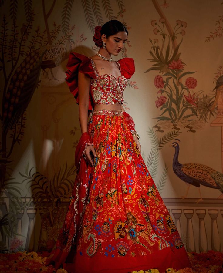 Editor's Note The red scarlet frill blouse, lehenga, and dupatta set is a mesmerizing ensemble that exudes grace and sophistication. The vibrant red color combined with the beautiful frill detailing adds a touch of femininity and elegance. The lehenga features a flared silhouette, and the matching blouse complements it perfectly. Complete with a stunning dupatta, this ensemble is sure to make a statement at any special occasion or celebration. Color: Red Fabric: Lehenga: crepe silk, blouse: raw Frill Lehenga, Blouse Lehenga, Blouse Yoke, Cape Tops, Personal Shopping Service, Frill Blouse, Drape Saree, Dupatta Set, Traditional Fashion