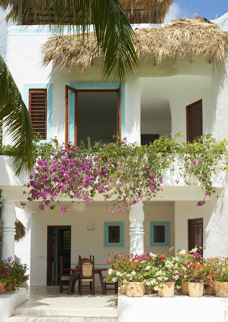 a white house with flowers on the balcony