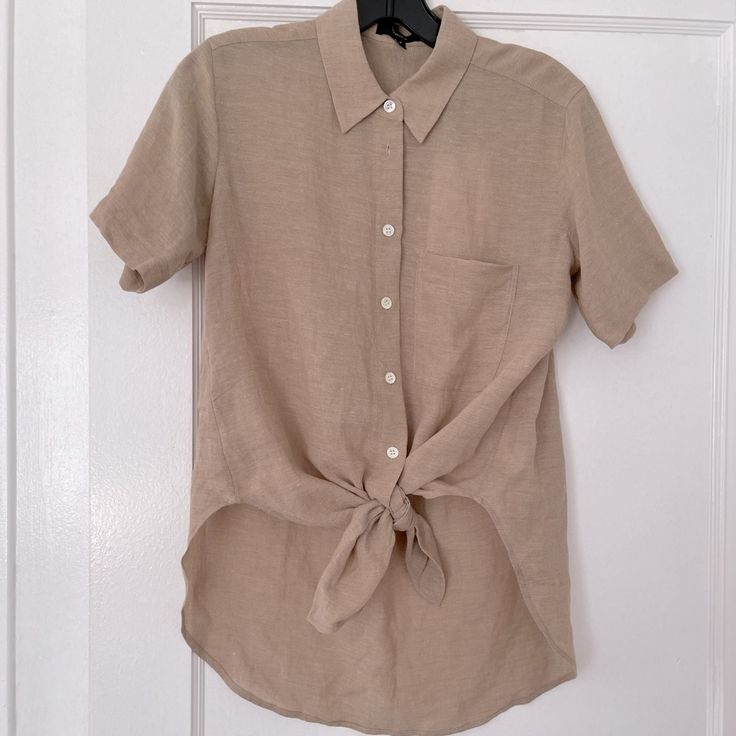 Brand New With Tags, Never Worn. Point Collar And Short Sleeves, Button Placket With Ties At Hem, Curved High-Low Hem. 70%Viscose,30%Linen Casual Beige Blouse With Buttons, Brown Tops With Button Closure For Daywear, Everyday Collared Blouse In Neutral Color, Everyday Neutral Collared Blouse, Beige Short Sleeve Blouse With Button Closure, Classic Neutral Blouse For Summer, Casual Neutral Shirt For Work, Beige Blouse With Button Closure And Short Sleeves, Neutral Linen Button-up Top