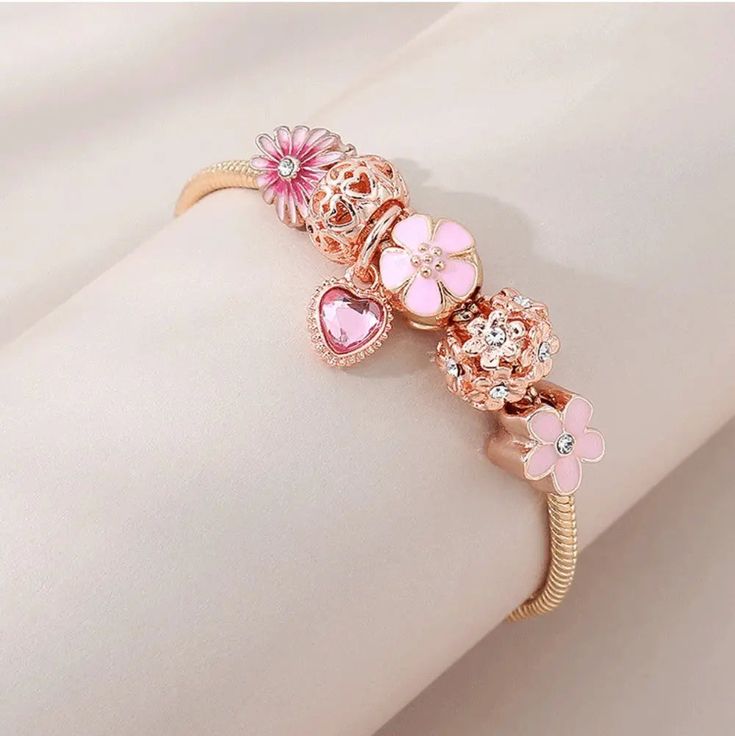 LOVCIA Pink Floral Daisy Love Fashion Bracelet for Women Enhance your jewelry collection with the LOVCIA Pink Floral Daisy Love Fashion Bracelet. This elegant bracelet features a blend of pink floral daisy charms, a heart charm, and sparkling crystals, making it a perfect accessory for any occasion. Crafted with high-quality materials and a stylish snake chain, it offers both beauty and durability. Key Highlights Beautiful pink floral daisy and heart charms with sparkling crystals High-quality copper alloy with gold plating for a luxurious look Adjustable length for a perfect fit on any wrist size Secure lobster claw clasp for easy wear and removal Elegant snake chain design for a sophisticated style Why You Should Buy This Bracelet Perfect gift for women who love elegant and trendy jewelr Elegant Pink Beaded Bracelet With Heart Charm, Elegant Pink Bracelet With Heart Charm, Dainty Pink Heart Charm Bracelet, Elegant Pink Heart Charm Bracelet, Pink Flower-shaped Metal Jewelry, Elegant Pink Bracelet With Flower Charm, Gold Flower Bracelets For Valentine's Day, Flower Shaped Charm Bracelet For Gift, Pink Bangle With Charms