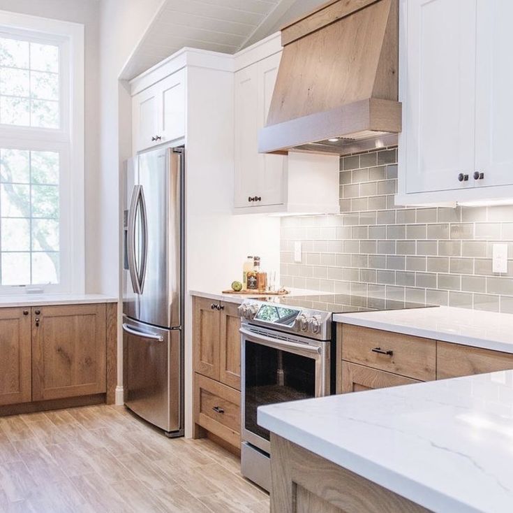 a kitchen with wooden cabinets and stainless steel refrigerator freezer combo in the center, along with white marble countertops