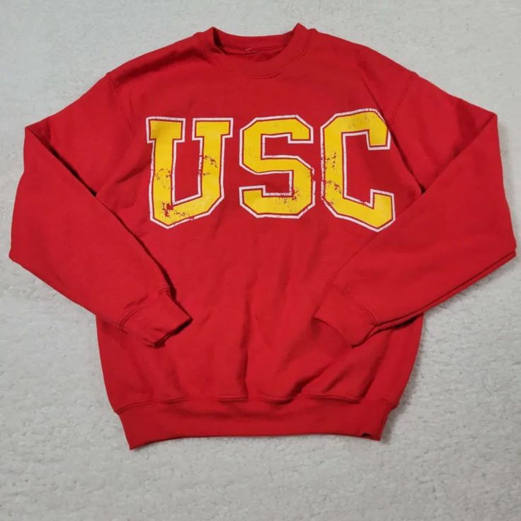 Features: - Crew Neck - 60% Cotton/40% Polyester - Usc Graphic Red Varsity Top With Ribbed Cuffs, Red Collegiate Cotton Sweater, Red College Sweater With Ribbed Cuffs, Retro Red Top With Ribbed Cuffs, Collegiate Yellow Crew Neck Top, University Red Varsity Sweatshirt With Crew Neck, University Red Varsity Crew Neck Sweatshirt, University Red Cotton Sweatshirt For Game Day, Yellow Crew Neck Top With Letter Print