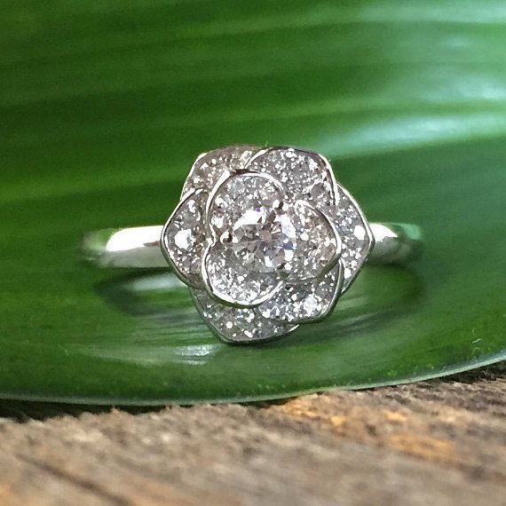 a diamond ring sitting on top of a green leaf