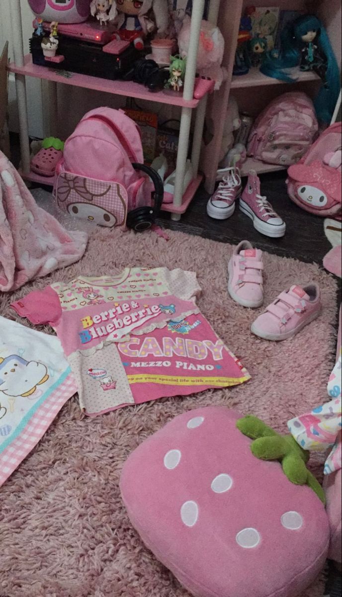 there are many pink items on the floor in this child's room, including books and toys