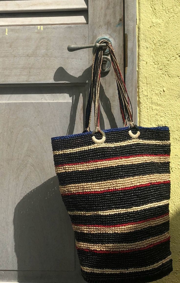 "Our \"Baobab\"  tote is extremely durable, exquisitely unique, and made from environmentally sustainable materials, this bag is perfect at the market, beach or around town!  Features: 100%  hand-crocheted raffia body Ethically sourced zebu (cattle) horn rings Individually Plaited (braided) handles-9\" drop Inside pocket ~17\" high x 15\" wide Your purchase helps empower female artisans working with La Floraison in Madagascar Available in black or turquoise Please note that due to the handmade nature of this product, slight variations in size and color may occur." Zebu Cattle, Horn Rings, Plait Braid, Horn Ring, Market Bags, Raffia Bag, Straw Tote, Beach Tote, Women Artisans